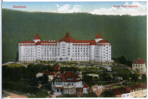 Eine alte Postkarte zeigt das Grand Hotel Imperial in Karlsbad, Deutschland, ein großes Gebäude mit zahlreichen Fenstern, umgeben von Bäumen und einem Hügel unter einem bewölkten Himmel, mit Text oben.