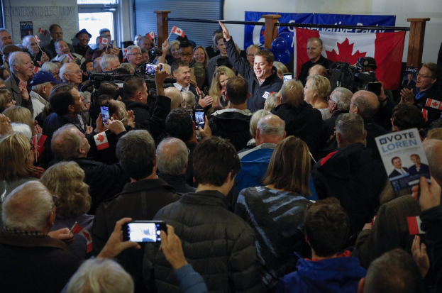 Eine Menge Menschen mit Kameras, Handys, Fahnen und Schildern vor einem Gebäude mit einem Banner, auf dem steht: "Loren Loren, der Vorsitzende der Liberalen Partei, wird von Unterstützern bei einer Wahlveranstaltung in Ottawa, Ontario, am Dienstag, dem 21. Januar 2020, empfangen."