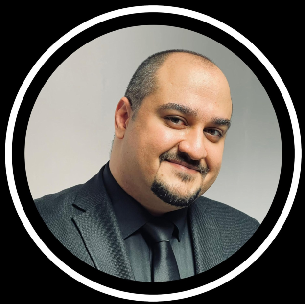 Ein Mann in Anzug und Krawatte, der fröhlich in die Kamera lächelt, vor einem schwarzen Hintergrund, betitelt mit "Anwalt in New York City."