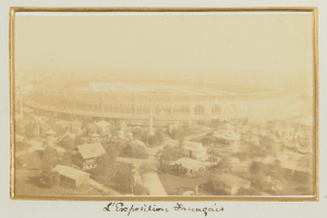 Altes Schwarz-Weiß-Foto eines Stadions inmitten einer Stadtlandschaft mit umliegenden Gebäuden, Bäumen und Strommasten sowie unten sichtbarem Text.