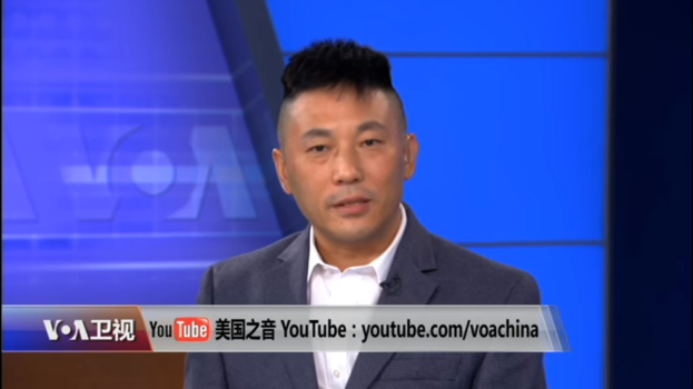 Ein chinesischer Nachrichtensprecher in Anzug und Krawatte, der auf einem Fernsehbildschirm spricht, mit Text unten und einem blauen Hintergrund.