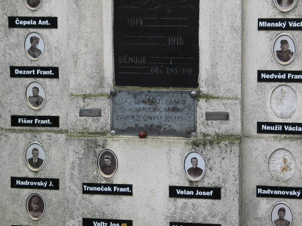 Eine Wandgedenktafel mit Fotos von Individuen und begleitendem Text, wahrscheinlich zum Gedenken an die im Zweiten Weltkrieg Verstorbenen.