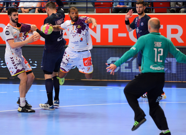 Männer beim Handballspielen auf einem Court mit einem Ball im Spiel, Zuschauern im Hintergrund und einer Tafel mit der Aufschrift Futsal-Weltmeisterschaft 2019.