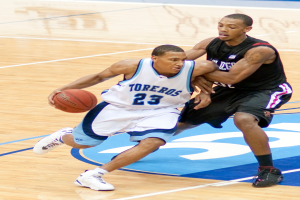 Zwei Personen spielen Basketball, eine hält den Ball.