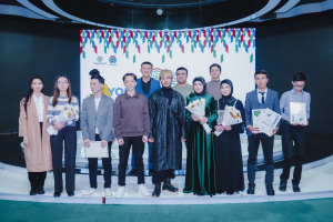 Gruppe von Menschen auf einer Bühne mit Blumensträußen und Urkunden, im Hintergrund ein Banner 'Jugend-Solar-Awards 2019'