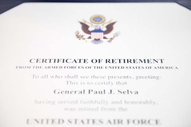 Rahmenurkunde der United States Air Force mit blauer Einfassung, die einen schwarzen Text und ein zentrales Sternsymbol innerhalb eines Lorbeerkranzes sowie ein Banner mit der Aufschrift "Rente" enthält.