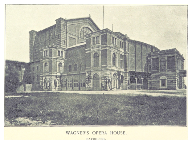 Schwarzes und weißes Foto von Wagners Opernhaus in Bayreuth mit ein paar Menschen vor dem Gebäude, umgeben von Bäumen und einem klaren Himmel, mit Text unten.
