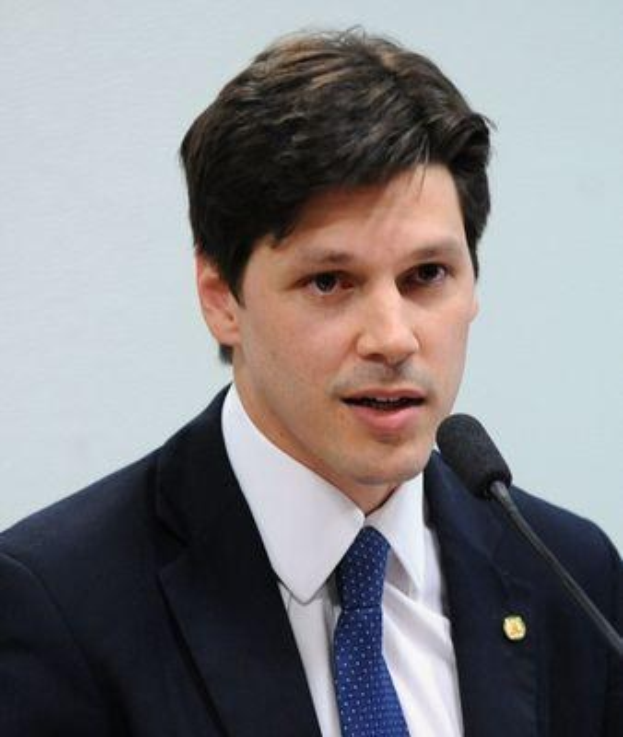 Ein Mann in Anzug und Krawatte spricht in ein Mikrofon an einem Podium, wahrscheinlich bei der Genehmigung eines Gesetzes durch die Regierung.